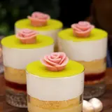 Fyra små prinsesstårta i glas, dekorerade med rosa marsipanrosor och gul marsipanlock. En festlig dessert!