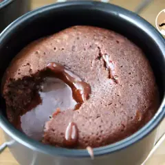 En chokladfondant med rinnande kärna i en svart form. En härlig dessert som smälter i munnen.