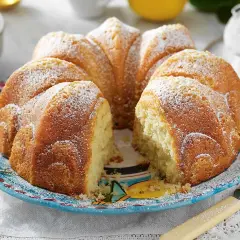 En saftig sockerkaka, perfekt att baka med grekisk yoghurt. Pudrad med florsocker och serverad på en vacker blå tallrik.