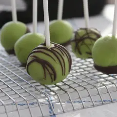 Gröna dammsugare kakor med chokladdroppar på ett galler.