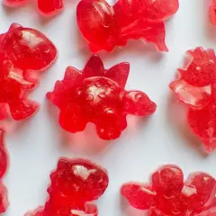 Röda dinosauriegummi, perfekta för ett roligt godis recept. Dessa små dinosaurier är redo att ätas!