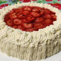 En vacker jordgubbsmousse tårta med rikligt med vispgrädde och färska jordgubbar på toppen. Perfekt för sommarens firanden.