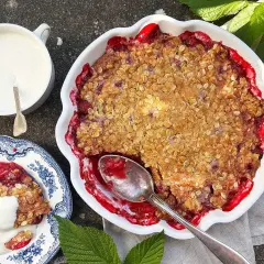 En härlig hallonpaj med krispig topping, serverad med vaniljsås. Perfekt för ett somrigt fika.