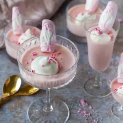 Rosa pannacotta med vispgrädde och skumtomtar, en söt och festlig dessert.