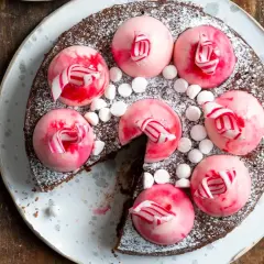 Chokladtårta med rosa polka pannacotta-toppar, strössel av florsocker och små marshmallows.
