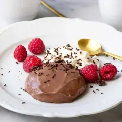 En krämig chokladpudding med hallon och vispad grädde, perfekt för ett enkelt chokladpudding recept.