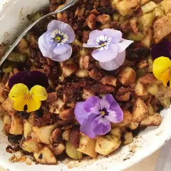 En härlig ansa rabarberpaj med krispigt täcke, dekorerad med vackra penséer.