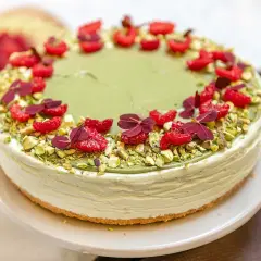 En krämig pistage cheesecake, dekorerad med hallon och pistagenötter. En dröm för alla sötsugna!