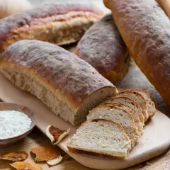 Färskt bröd, potatis och en skål med mjöl, kanske istället för potatismjöl, för en rustik bakning.