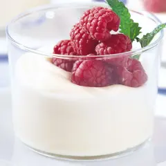 En len vit chokladmousse i glas, toppad med färska hallon och en myntakvist. En perfekt dessert för alla tillfällen.