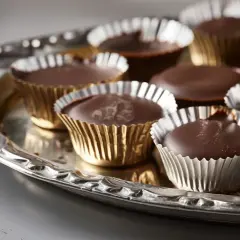 Chokladpraliner i guldfärgade formar på ett silverfat. Perfekt för ett enkelt ischoklad recept.