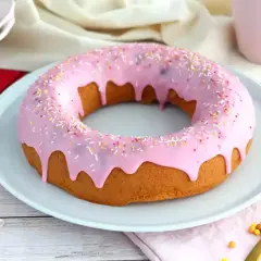En stor donut tårta med rosa glasyr och strössel. Perfekt för ett kalas!