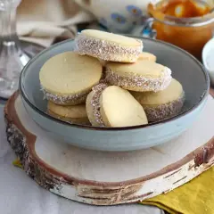 En skål med alfajores, perfekta för överblivna äggulor recept. Dessa småkakor är fyllda med dulce de leche och rullade i kokosflingor.