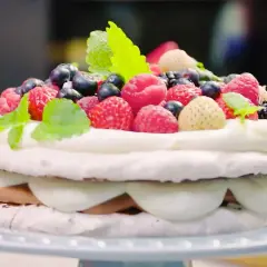 En vacker marängtårta med grädde och färska bär, som en härlig rice crisp tårta.