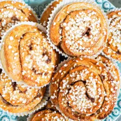 En tallrik med gyllene, snabba bullar toppade med pärlsocker. Perfekt för fikat!