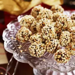 En hög med chokladtryffel täckta av hackade nötter på ett glasfat. Perfekt för fikat eller som en gåva.