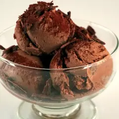 En skål med krämig chokladglass, toppad med chokladspån. Perfekt för ett enkelt chokladglass recept.