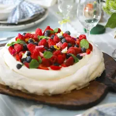 En vacker pavlova med grädde och färska bär, perfekt för ett sommarfika. Ett enkelt pavlova recept att följa.