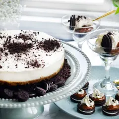 En krämig oreo cheesecake med krossade oreos på toppen. Serveras med små oreo-desserter och i glas.