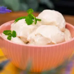 En skål med krämig nice cream, toppad med mynta. Perfekt för en varm sommardag.