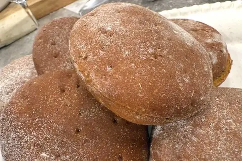 En hög med nybakade rågkakor, perfekta för ett enkelt rågkaka recept. Strödda med mjöl.