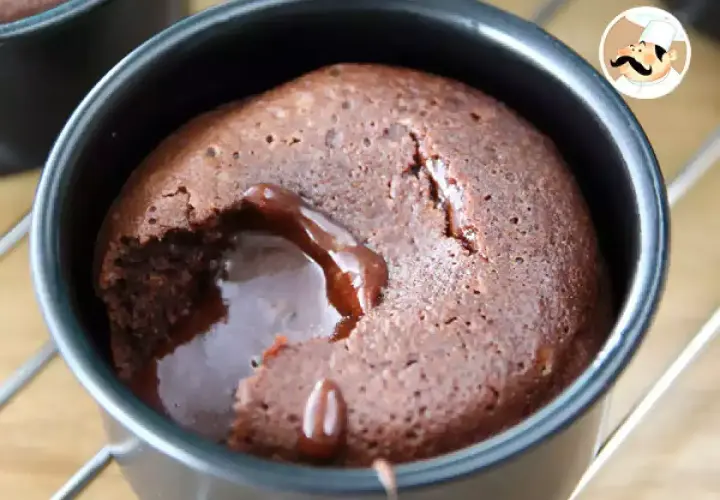 En chokladfondant med rinnande kärna i en svart form. En härlig dessert som smälter i munnen.