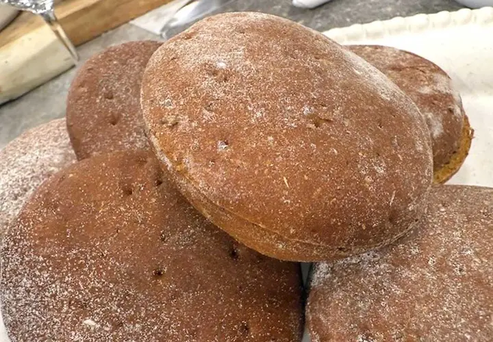 En hög med nybakade rågkakor, perfekta för ett enkelt rågkaka recept. Strödda med mjöl.