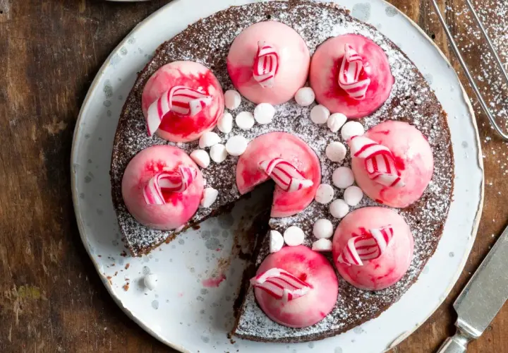 Chokladtårta med rosa polka pannacotta-toppar, strössel av florsocker och små marshmallows.