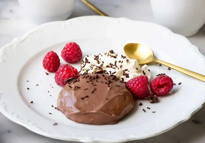 En krämig chokladpudding med hallon och vispad grädde, perfekt för ett enkelt chokladpudding recept.