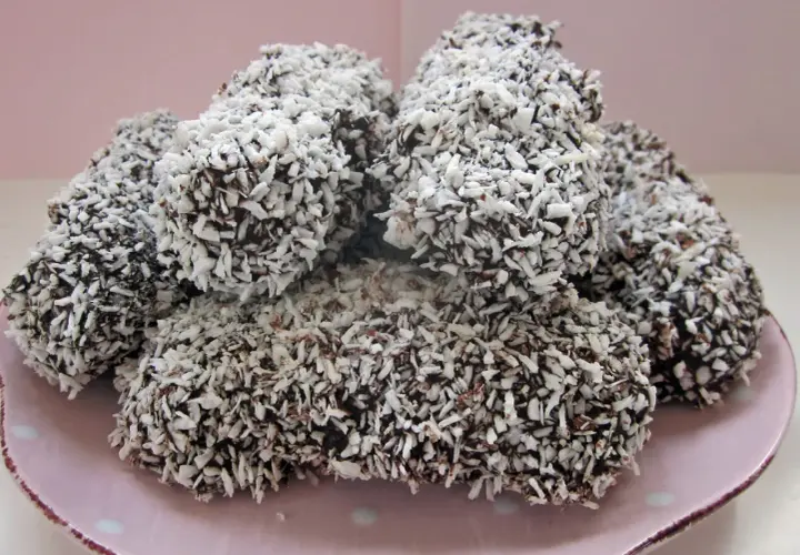 En hög med chokladöverdragna skumbollar, rullade i kokosflingor. Perfekt för ett enkelt skumbollar recept.