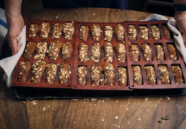 En form med nybakade, saftiga kavringsmuffins toppade med frön och havre. Perfekt för fikat!