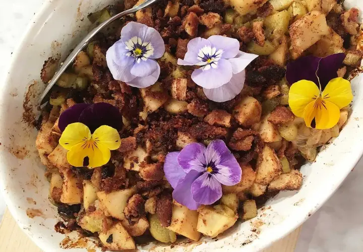 En härlig ansa rabarberpaj med krispigt täcke, dekorerad med vackra penséer.