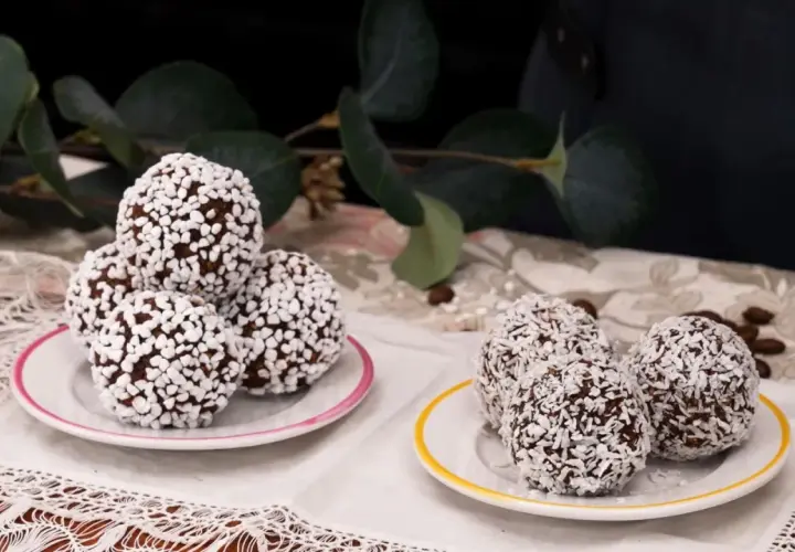 Två fat med chokladbollar, några rullade i kokosflingor och andra i små vita strösselkulor. En härlig syn av kokos bollar!