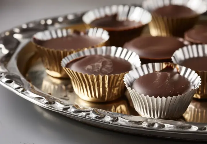 Chokladpraliner i guldfärgade formar på ett silverfat. Perfekt för ett enkelt ischoklad recept.
