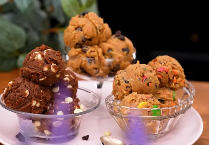 Tre skålar med olika sorters cookie dough recept: choklad med vita chokladknappar, klassisk med chokladknappar och en med färgglada godisbitar.