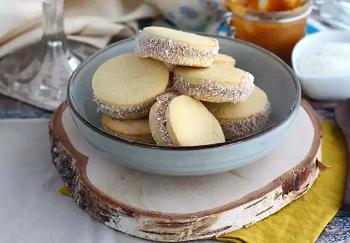 En skål med alfajores, perfekta för överblivna äggulor recept. Dessa småkakor är fyllda med dulce de leche och rullade i kokosflingor.
