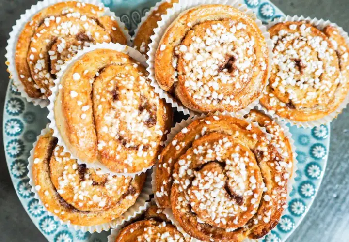 En tallrik med gyllene, snabba bullar toppade med pärlsocker. Perfekt för fikat!
