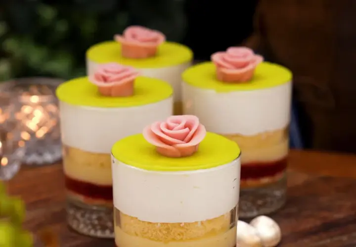 Fyra små prinsesstårta i glas, dekorerade med rosa marsipanrosor och gul marsipanlock. En festlig dessert!