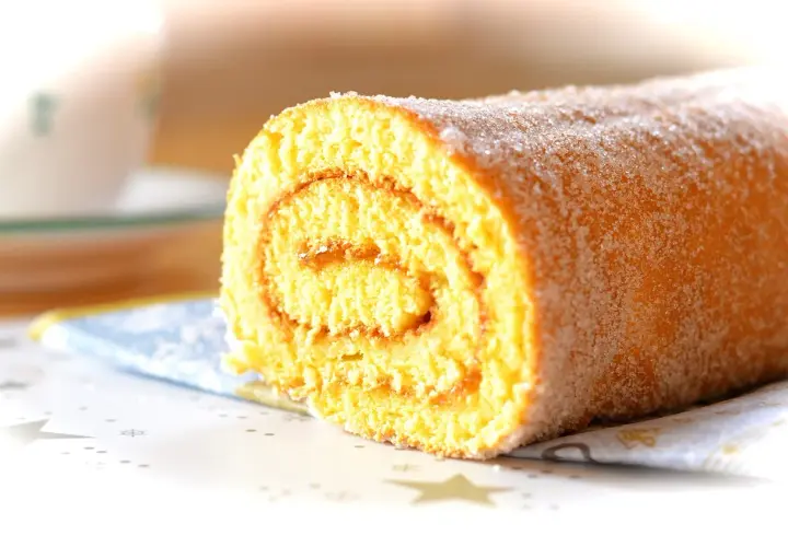 En saftig rulltårta med sockerströssel, perfekt för ett enkelt rulltårta recept.