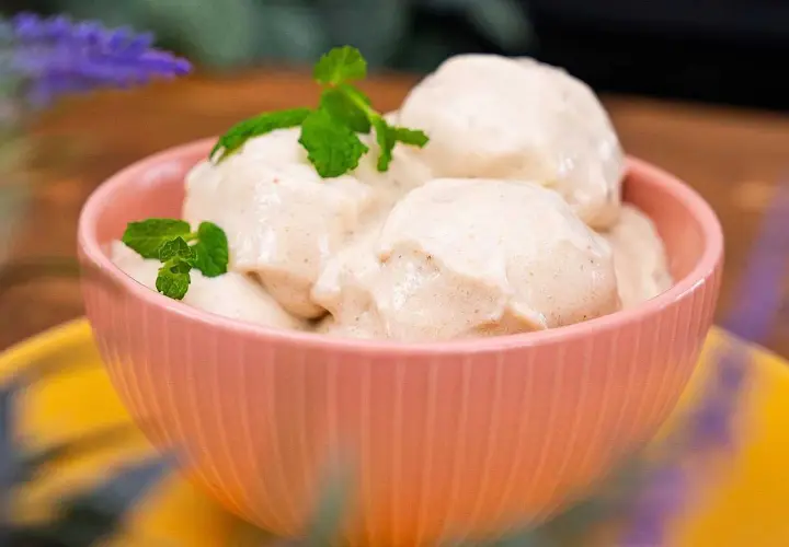 En skål med krämig nice cream, toppad med mynta. Perfekt för en varm sommardag.