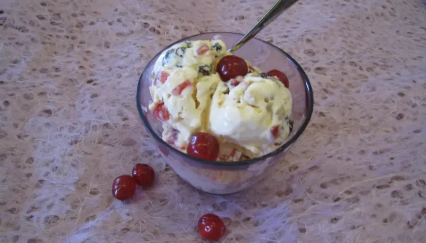 En skål med krämig glass, toppad med körsbär och bitar av frukt. En perfekt cassata glass för en varm dag.