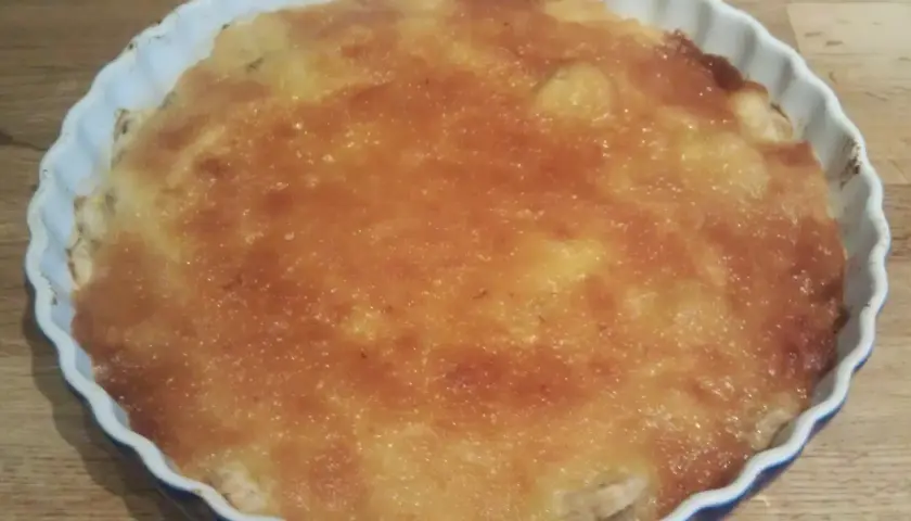 En gyllene bananpaj i en vit form, redo att avnjutas. Ett perfekt bananpaj recept för fikat.