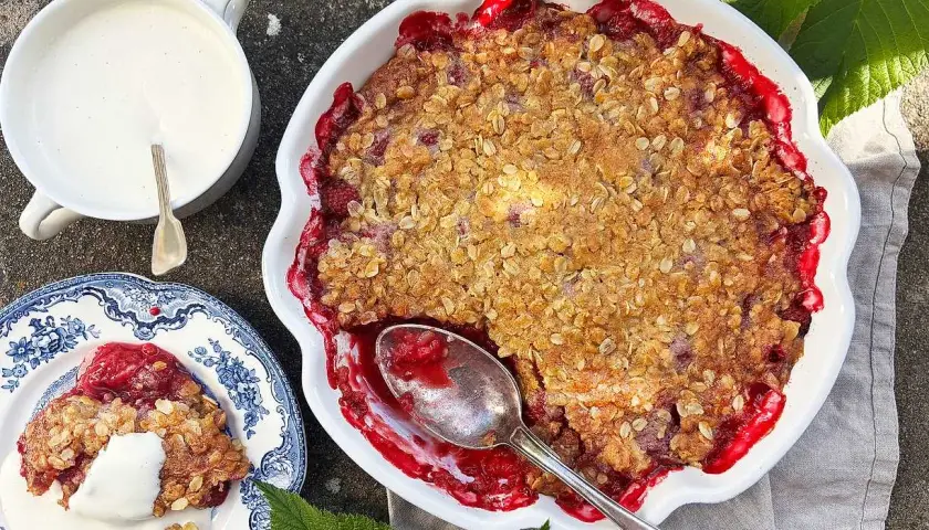 En härlig hallonpaj med krispig topping, serverad med vaniljsås. Perfekt för ett somrigt fika.