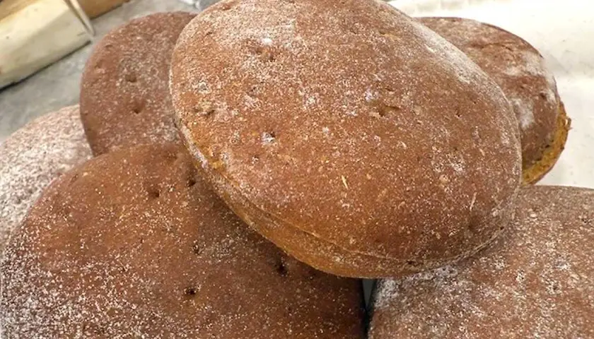 En hög med nybakade rågkakor, perfekta för ett enkelt rågkaka recept. Strödda med mjöl.