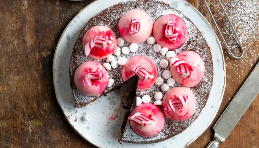 Chokladtårta med rosa polka pannacotta-toppar, strössel av florsocker och små marshmallows.