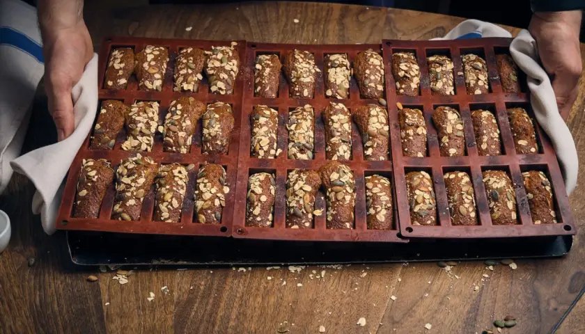 En form med nybakade, saftiga kavringsmuffins toppade med frön och havre. Perfekt för fikat!