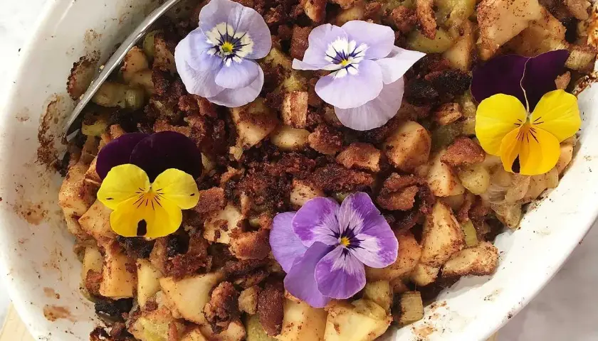 En härlig ansa rabarberpaj med krispigt täcke, dekorerad med vackra penséer.