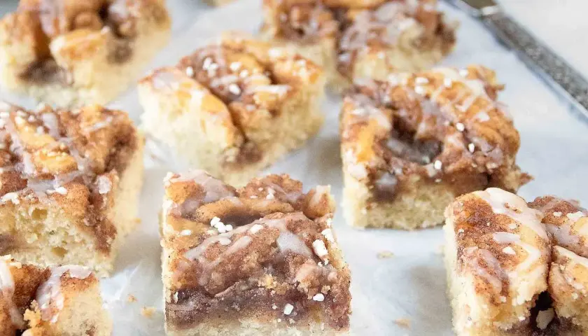Kanelbullekaka i långpanna, skuren i fyrkantiga bitar med glasyr och pärlsocker. Perfekt för fikat!