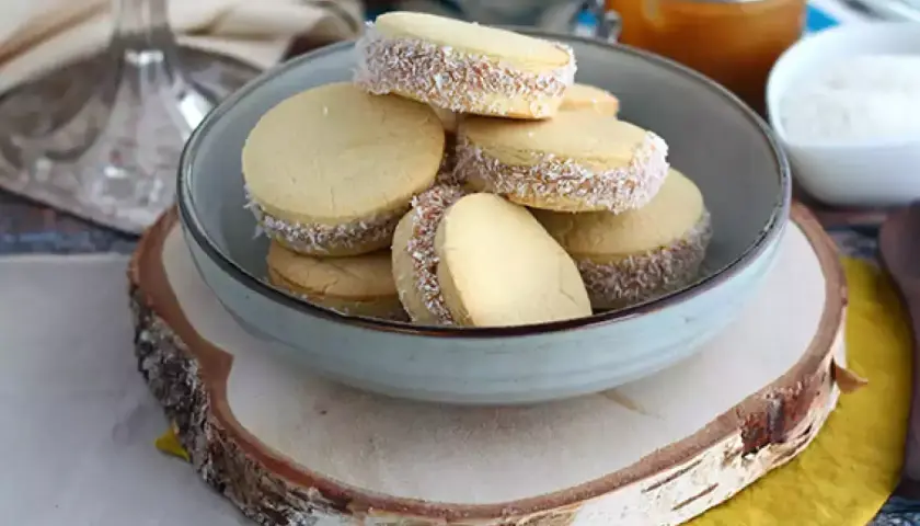 En skål med alfajores, perfekta för överblivna äggulor recept. Dessa småkakor är fyllda med dulce de leche och rullade i kokosflingor.