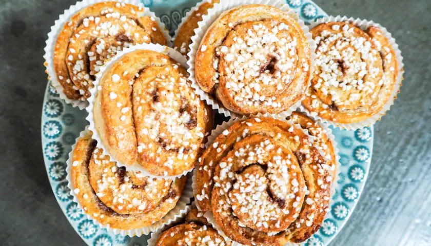 En tallrik med gyllene, snabba bullar toppade med pärlsocker. Perfekt för fikat!